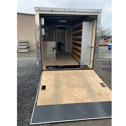 Back view of open Generac cargo trailer with shelving and work space.