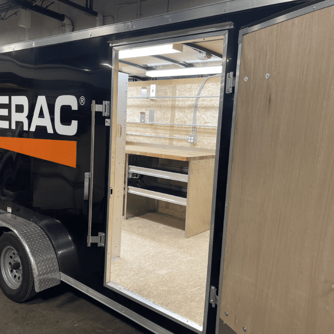 Side view of open Generac cargo trailer with shelving and work space.