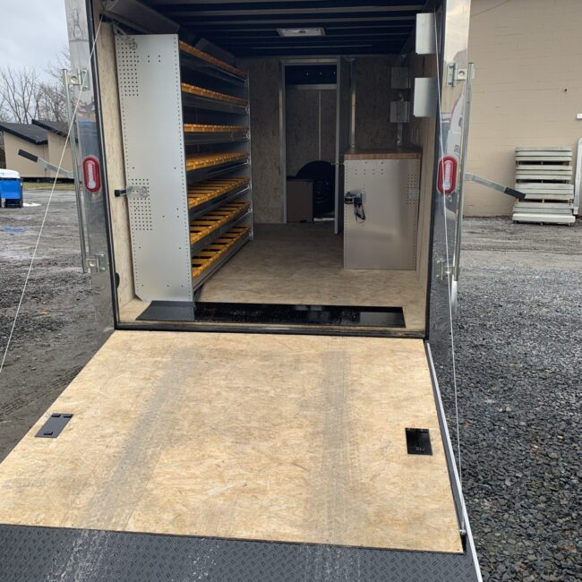 Back view of open Generac cargo trailer with shelving and work space.