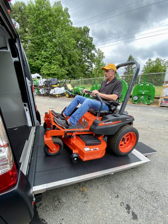 Check out our ramp installed on a Ford Transit shown fully open with man loading a riding lawnmower.